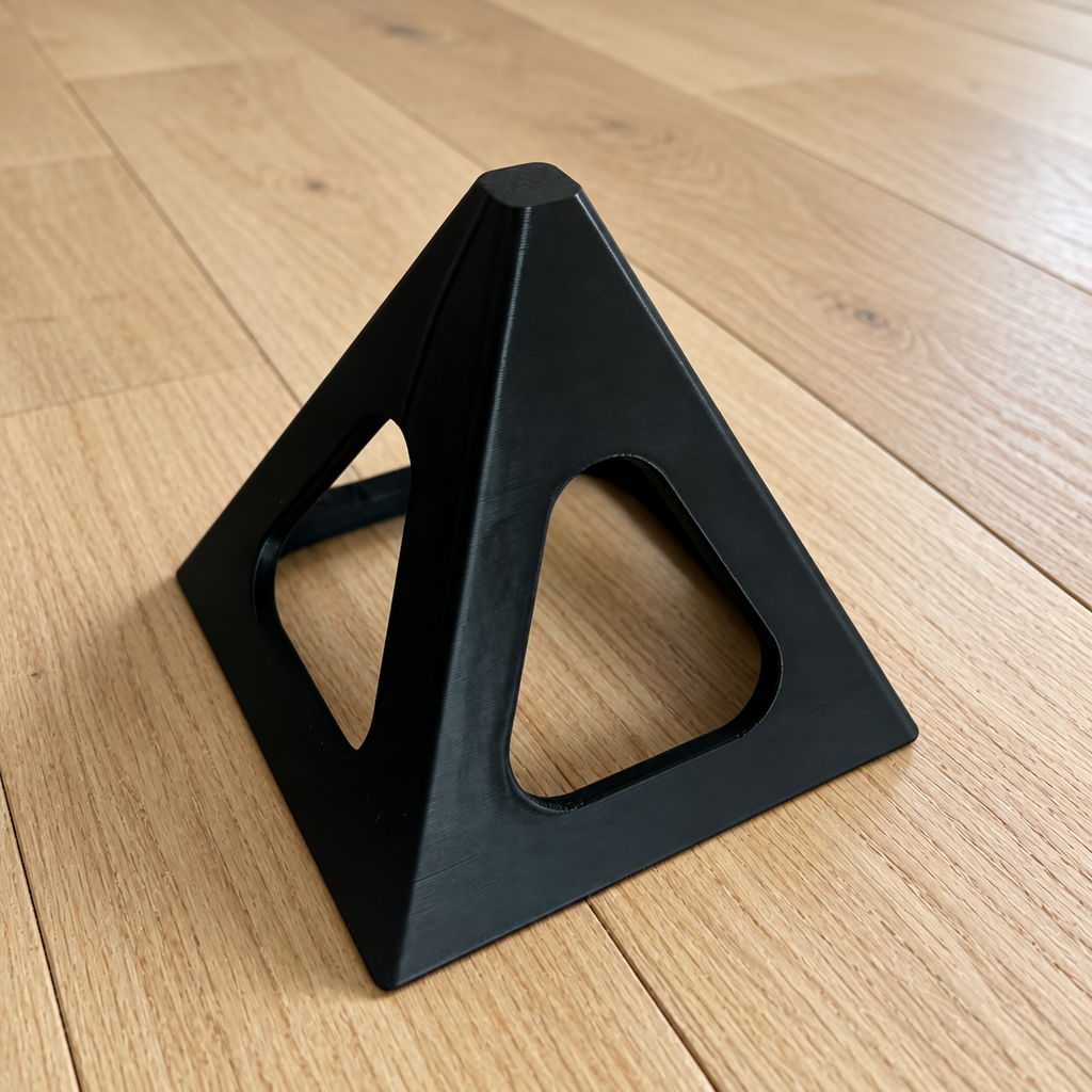 Black reusable painting pyramid stand on a white oak floor