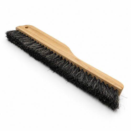 Long wooden plaster texturing brush with dense black bristles on white